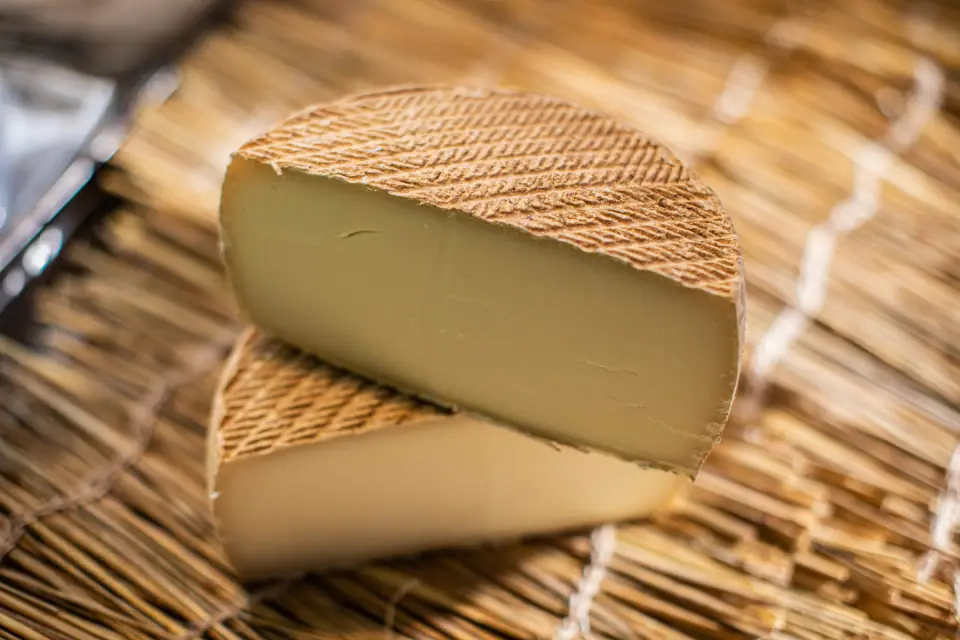 Tomme entamée posée sur la paille